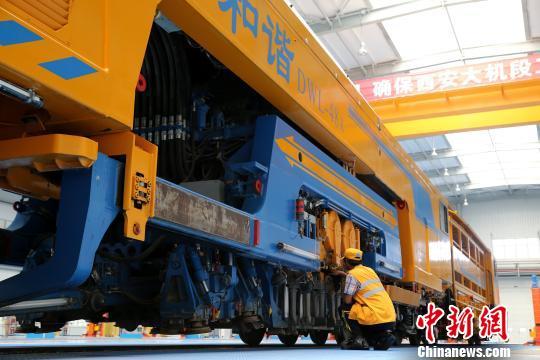 圖為工人正在清理大型養路機械。　張遠 攝